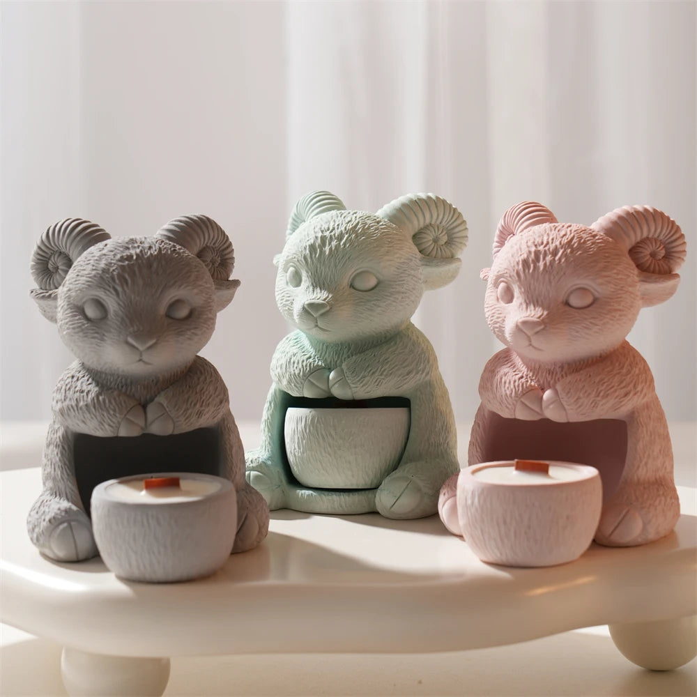 Gray, mint and pink seated ram holders shown with round candle cups