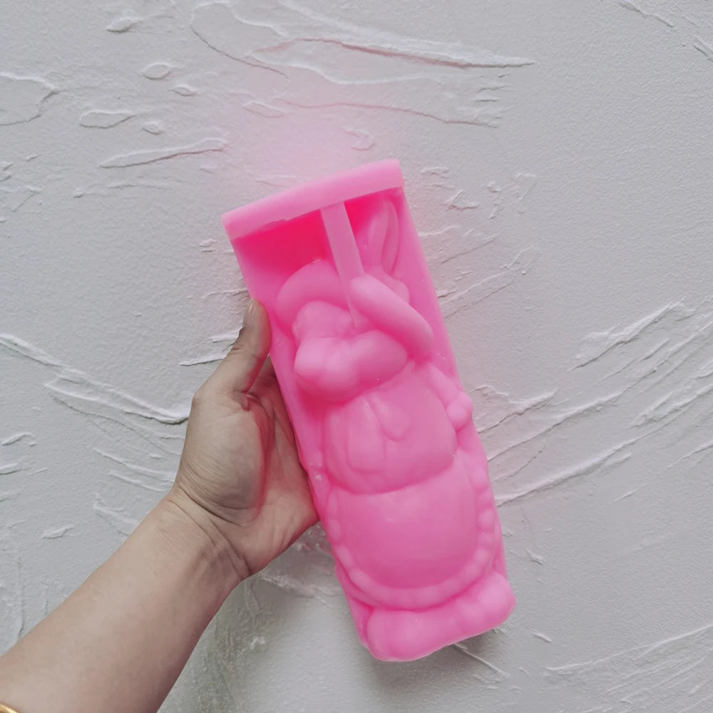 Pink bonnet-and-apron rabbit silicone mold held in one hand