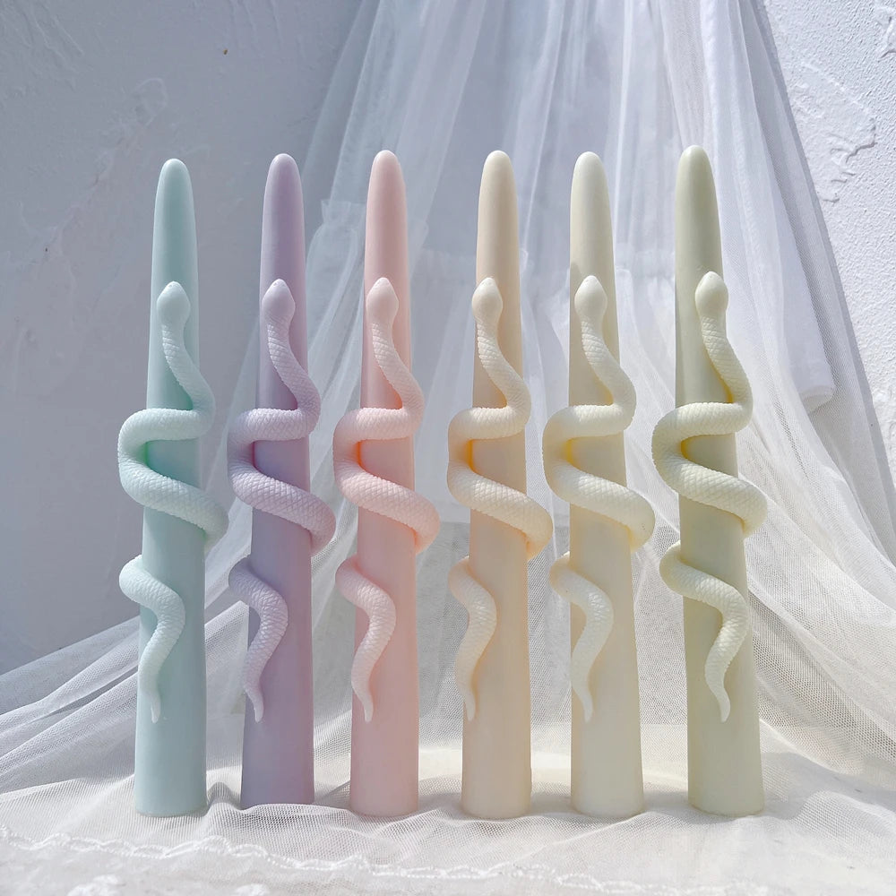 Pastel slender taper candle castings wrapped with winding snakes