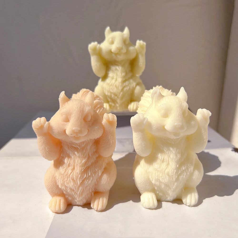 Squirrel castings with raised paws in pale orange and ivory wax