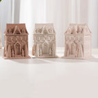 Three closed gingerbread house containers with raised architecture