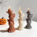 Three ghost stacks beside decorative Halloween pumpkins