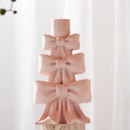 Pink stacked bow holder showing sculpted loops and ribbon tails