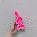 Pink silicone mold for treble clef and integrated oval base