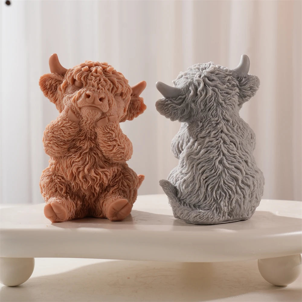 Front and rear views of seated Highland cow candles