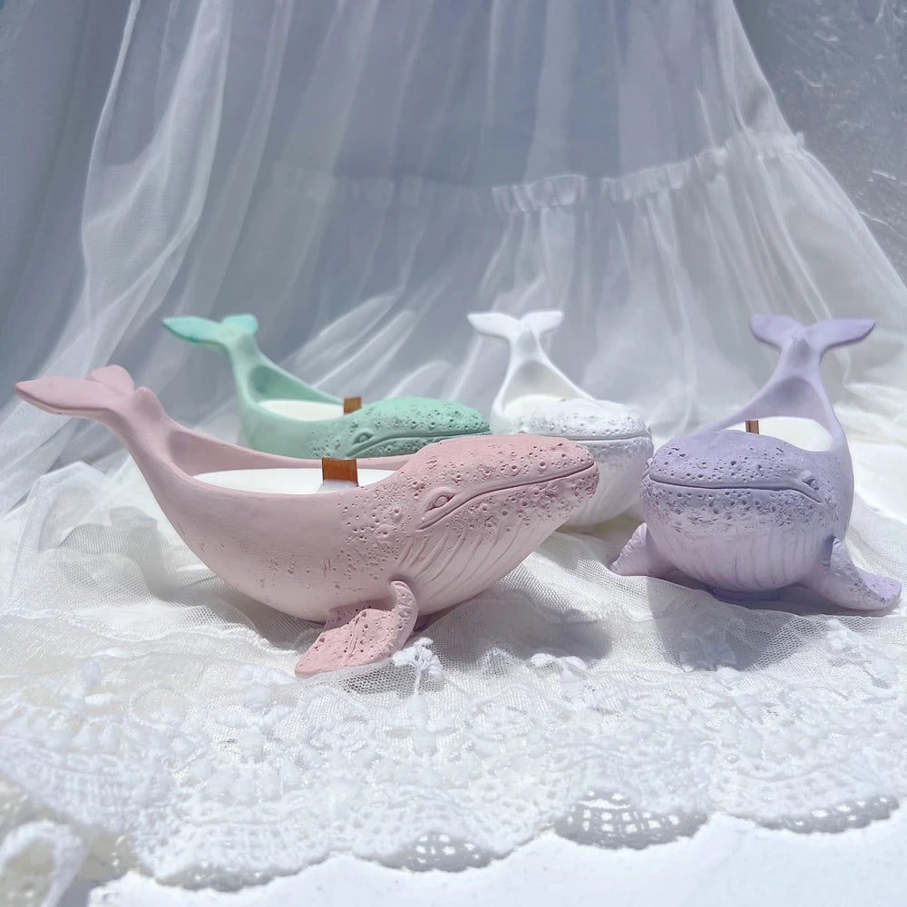 Pastel whale holder castings with sculpted faces and side fins