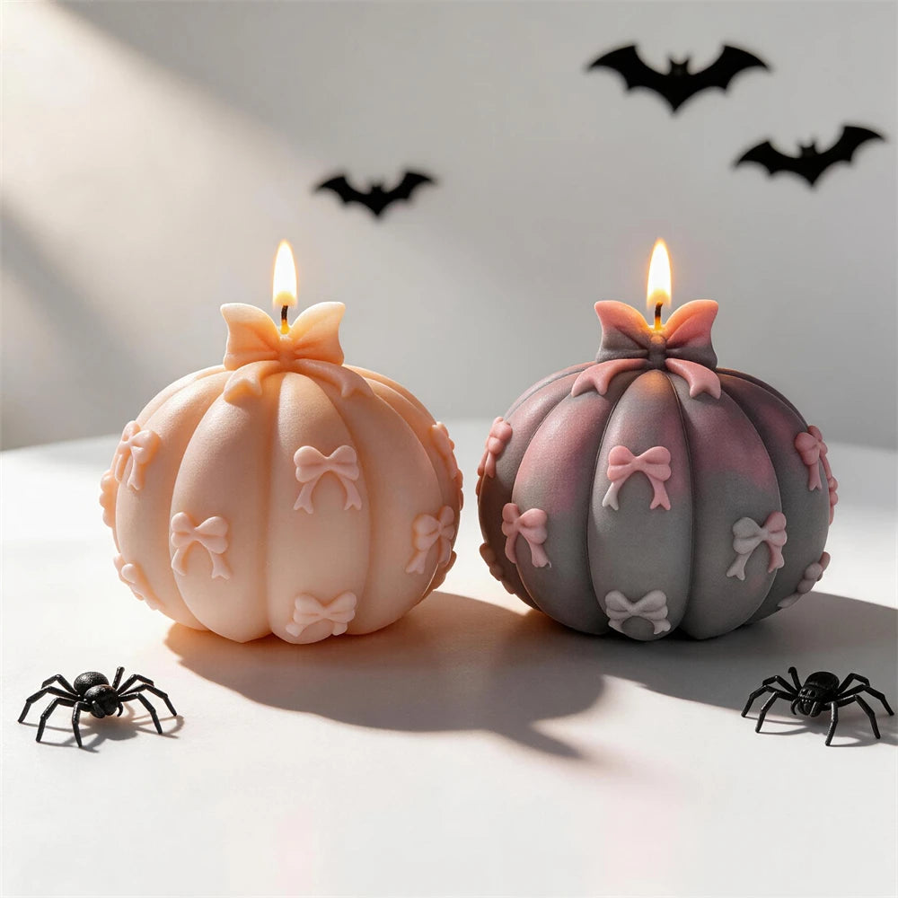 Lit bow-decorated pumpkin candles in peach and gray