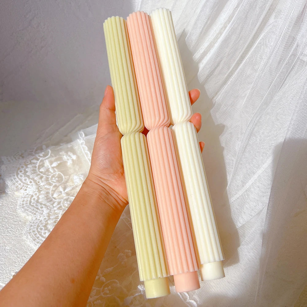 Three ribbed waisted taper castings held in one hand
