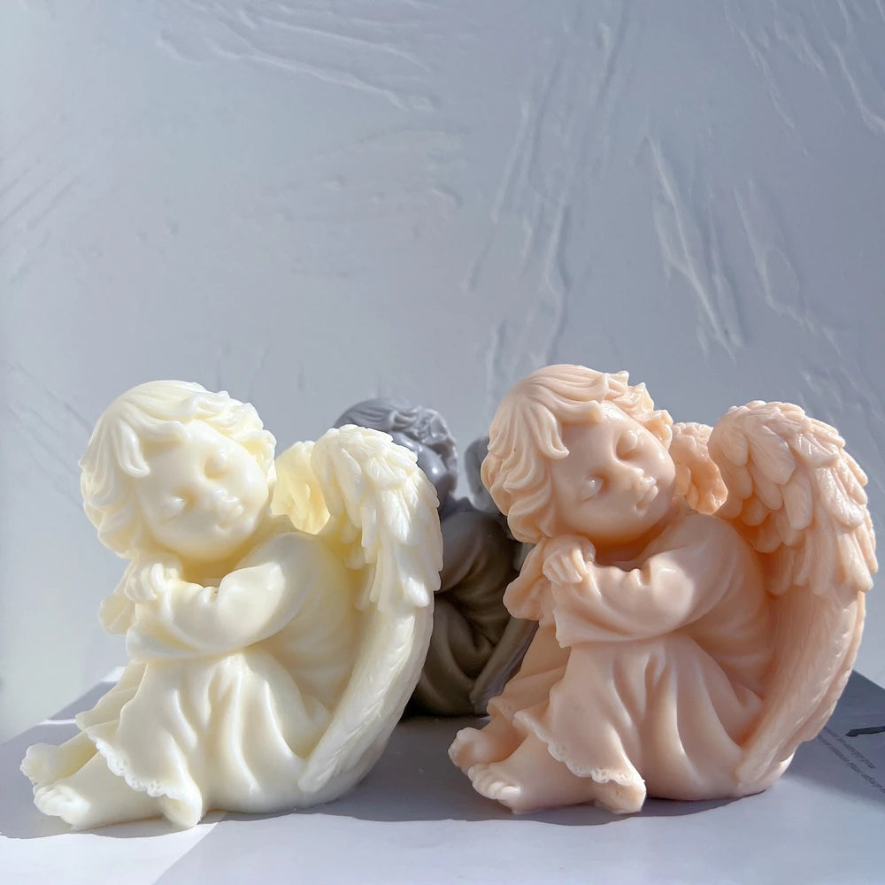 Seated cherub figurines with tilted heads and folded arms