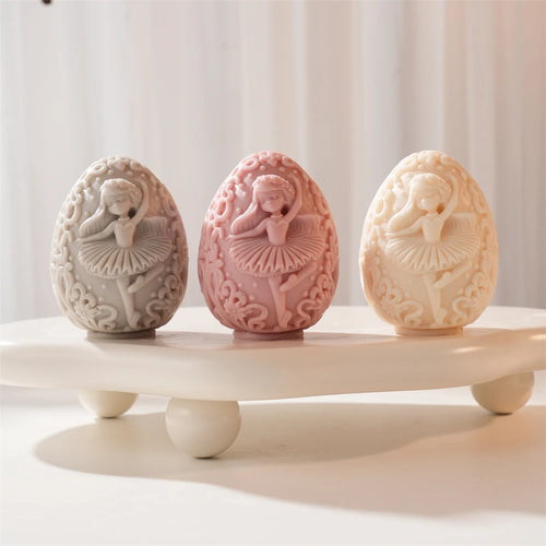 Three egg candles with ballerina and scrollwork relief