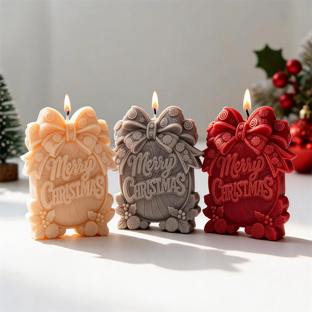 Three bow-topped Merry Christmas candles beside holiday ornaments