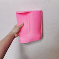 Pink western boot silicone candle mold held in one hand