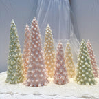 Detailed snowy Christmas tree candles in staggered heights