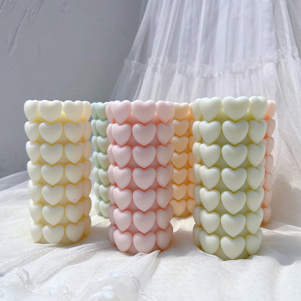 Rows of small hearts wrapping around sculptural pillar candles
