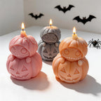 Three stacked pumpkin candles with round eyes and neck bows