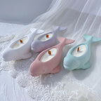 Pastel beluga whale decorative castings arranged on white fabric
