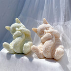 Seated cat castings holding curled fluffy tails