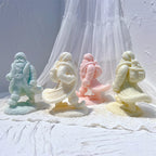 Three walking Santa candle figures with flowing coats