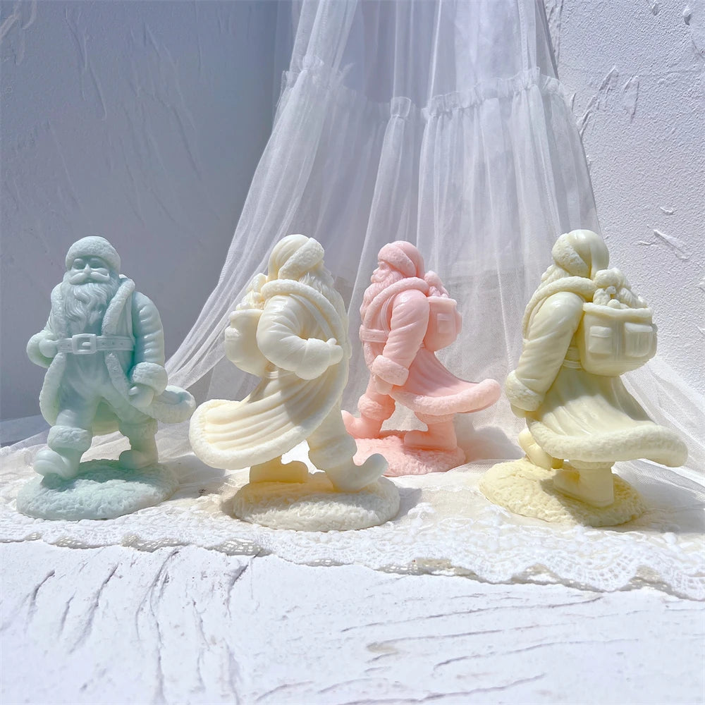 Three walking Santa candle figures with flowing coats