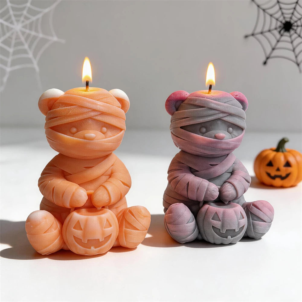 Orange and gray mummy bear candles holding pumpkins