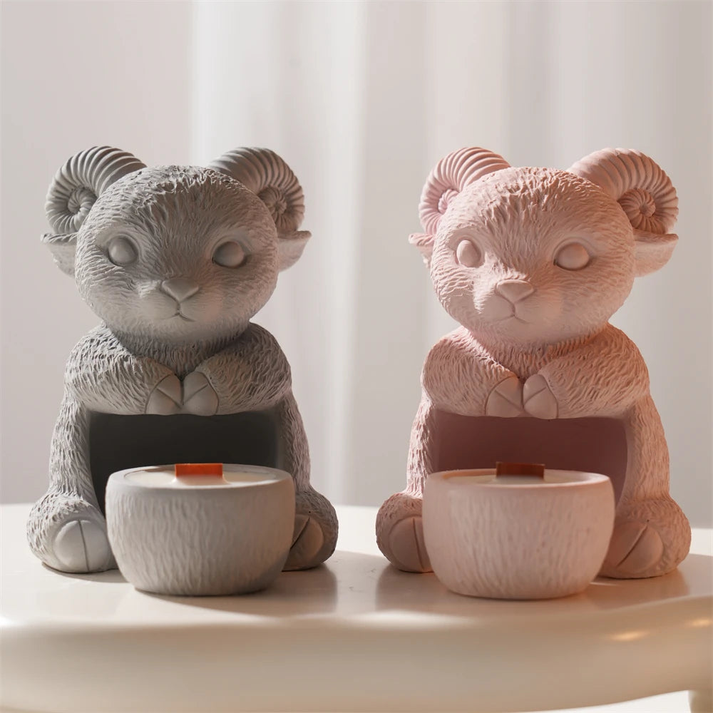 Gray and pink seated ram holder castings with curled horns and front cups