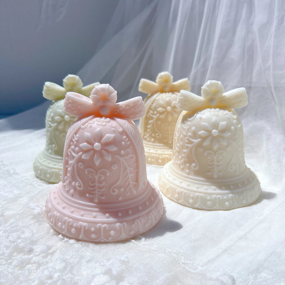 Gingerbread-style bell candles arranged on a white winter display