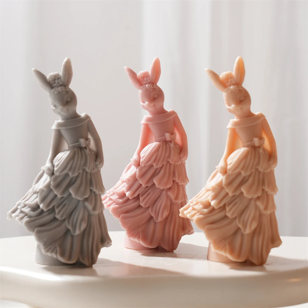 Gray pink and peach rabbit figures in ruffled dresses