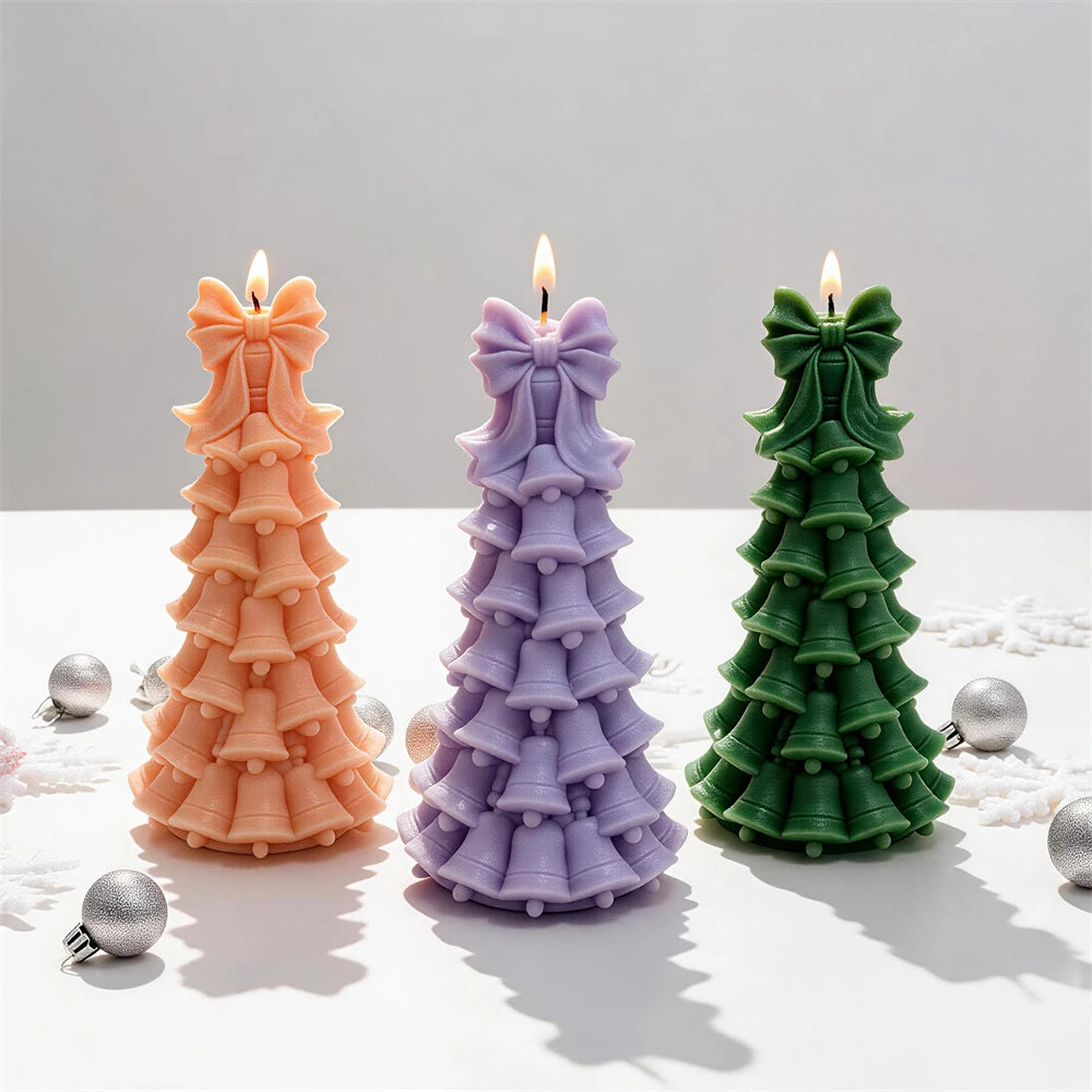 Three layered bell tree candles arranged beside festive ornaments