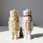 Two nutcracker figurine containers showing sculpted uniforms and hats