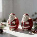 Pair of red and white Santa-shaped holiday decorative castings on a display surface