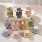 Pastel owl jars with hats removed beside them