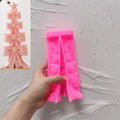 Pink silicone bow-stack tree mold held beside a finished example