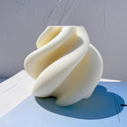 Rounded spiral candle form with sweeping folds and deep channels
