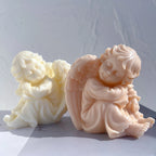Cream and peach seated cherub castings with curled hair and feathered wings