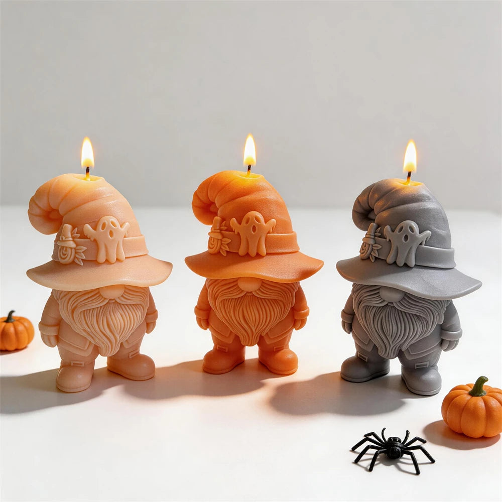 Ghost hat gnome candle group beside pumpkins and decorative cobwebs