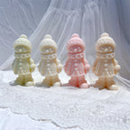 Four clothed winter figure castings with buttoned coats
