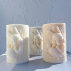 Angled view of cylindrical candles with seated rabbit reliefs