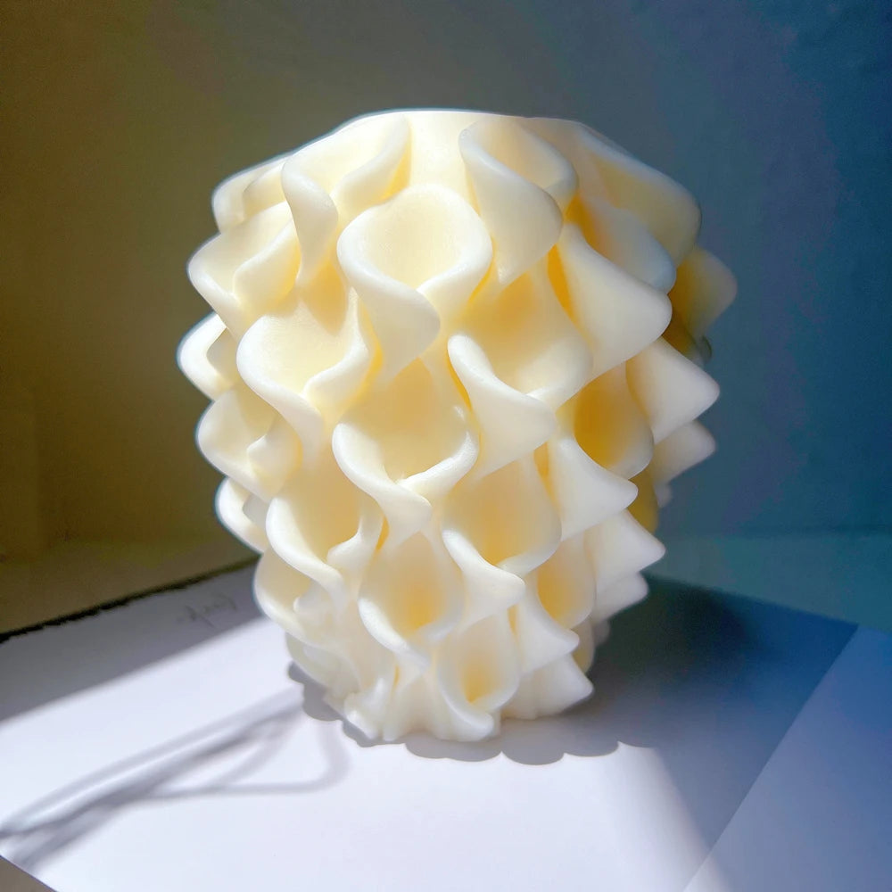Single cream-colored upright candle covered in overlapping petal-like ridges