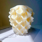 Single cream-colored upright candle covered in overlapping petal-like ridges
