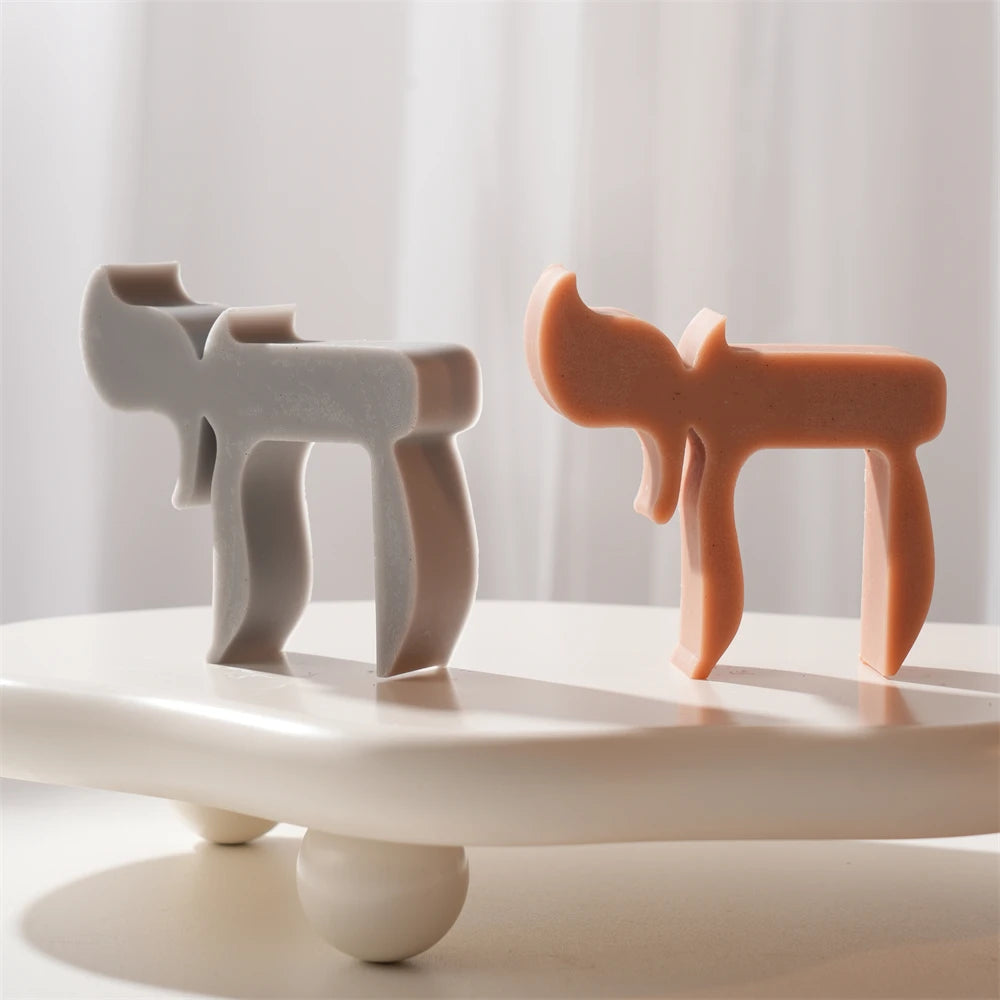 Gray and orange standing Chai form candles with geometric silhouette