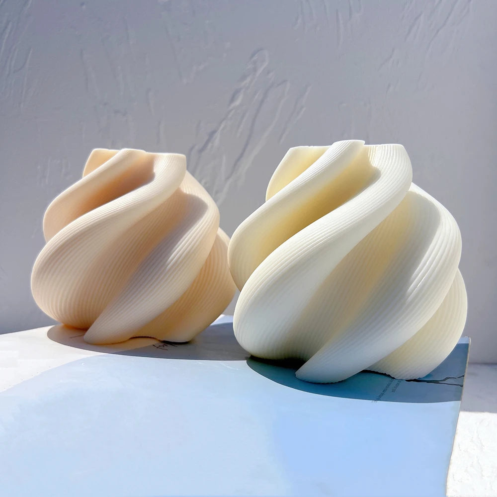 Beige and ivory spiral-ribbon figures side by side