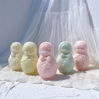 Five Russian doll candle figures in cream green and pink with painted-style relief