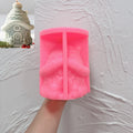 Pink silicone snow roof cottage mold held open in a hand
