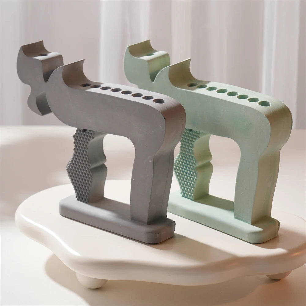 Gray and green Chai-shaped holder castings with rows of circular candle openings