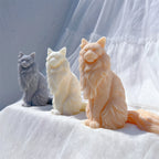 Three cat castings showing pointed ears and long fur
