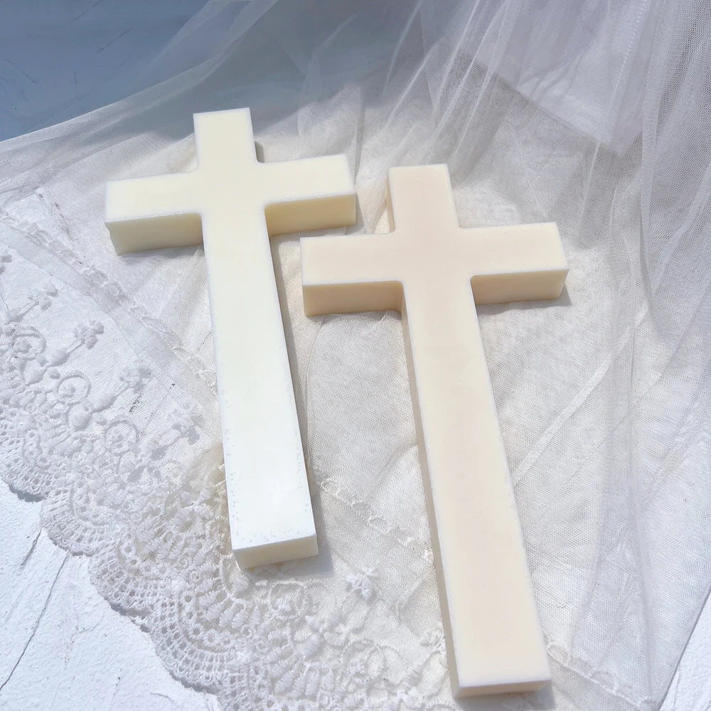 Two plain cross castings lying on textured white fabric