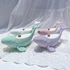 Whale-shaped holders showing long bodies and upturned tails