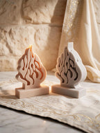 Unlit cream and gray flame-shaped castings viewed from three-quarter angle