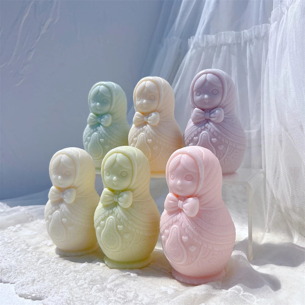 Russian nesting doll candle castings arranged on a white textured surface