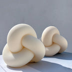 Two cream knot candles displayed together